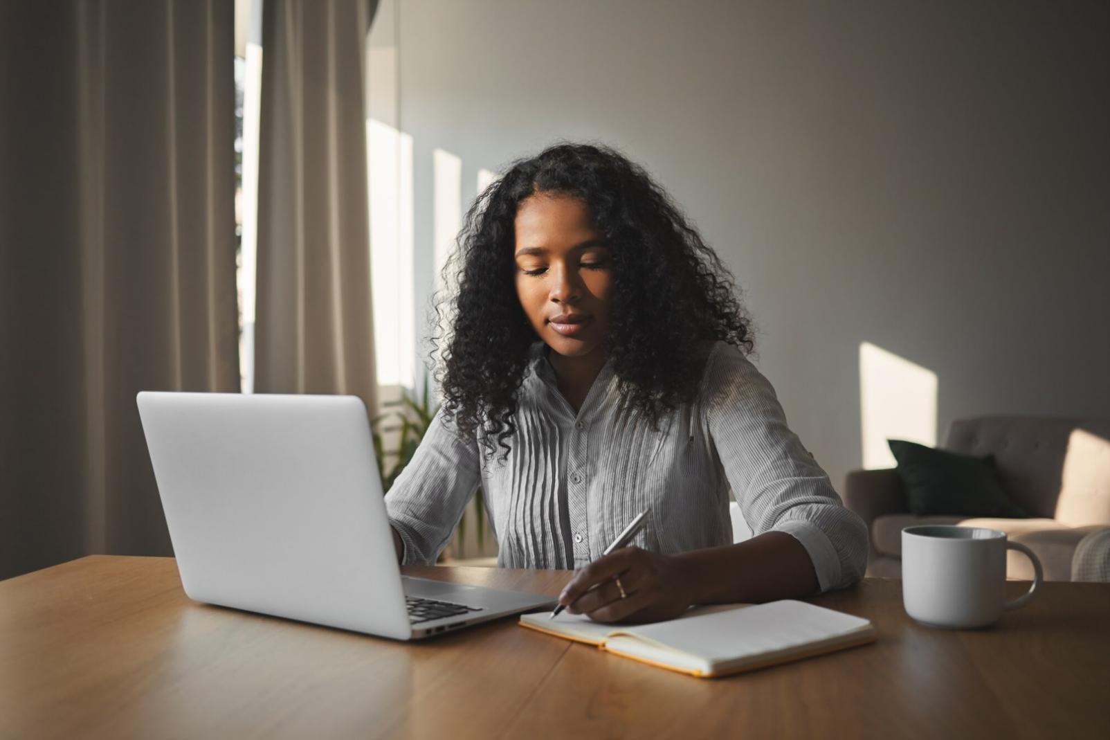Persona revisando su presupuesto mensual con documentos y calculadora sobre escritorio